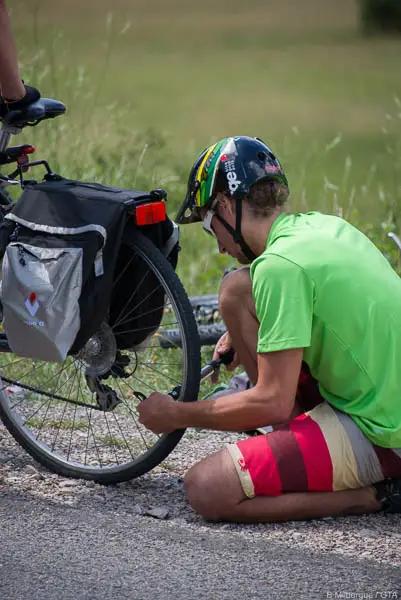 Cycliste réparant une crevaison en montagne