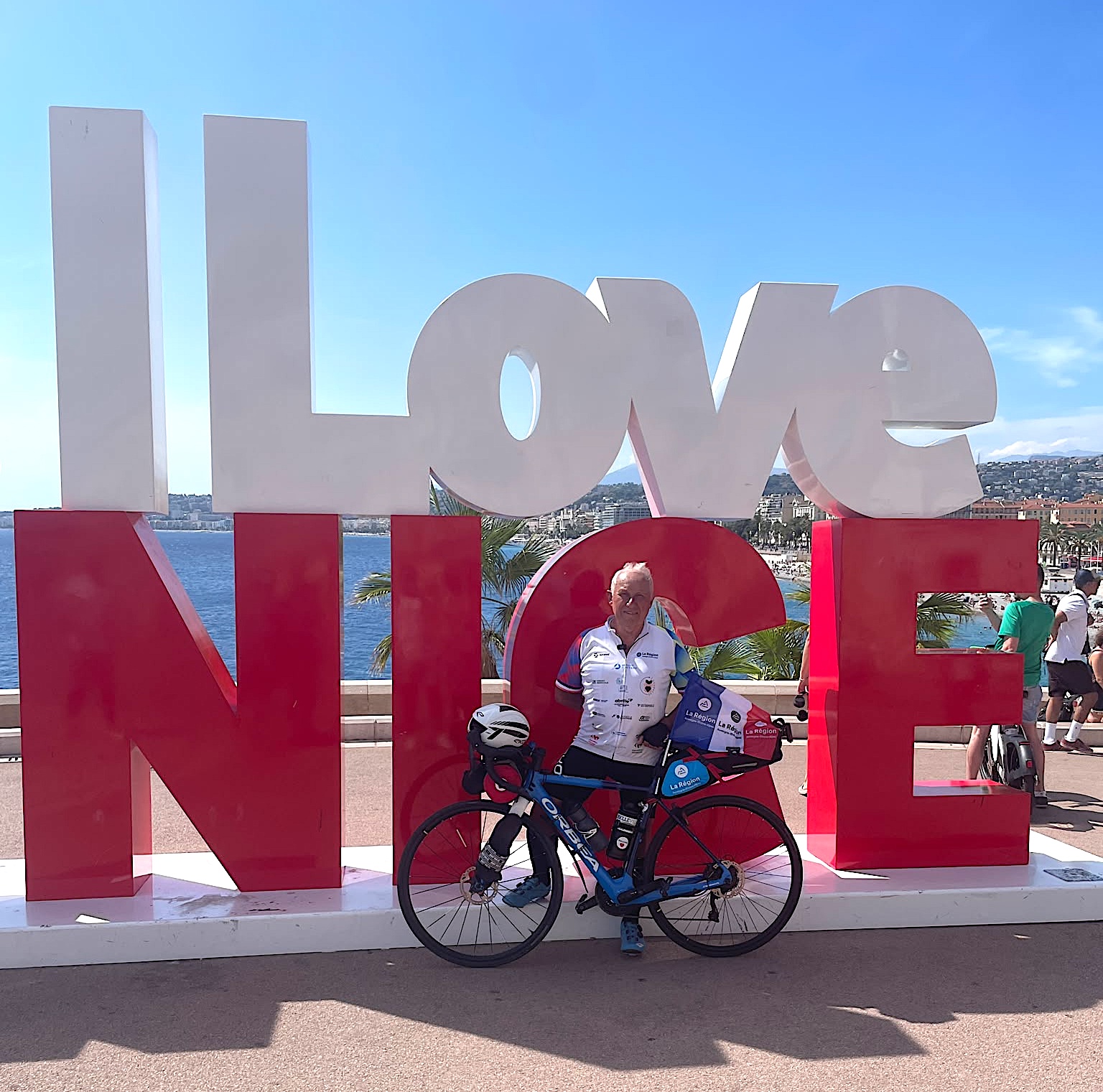 Papy Robert et son vélo devant le I Love Nice à l'arrivée de son défi sur la Route des Grandes Alpes