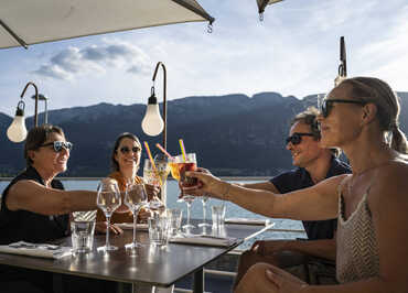 amis à l'apéritif sous parasol vue sur le lac d'annecy