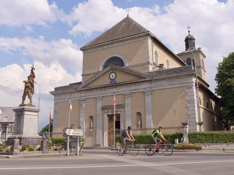 Cyclistes devant l'Église Saint-Jean-Baptiste de Taninges