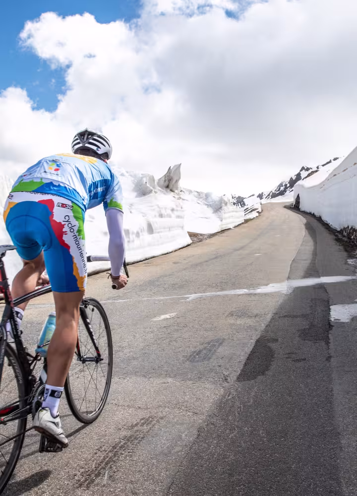Cycliste dans la neige sur Route des Grandes Alpes