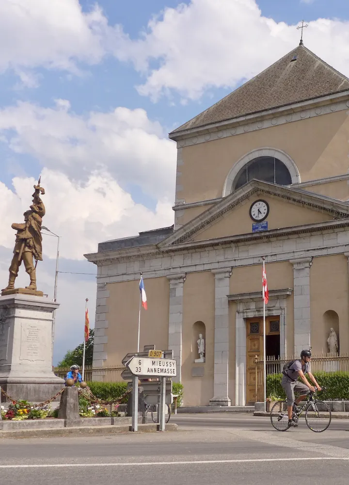 Cyclistes devant l'Église Saint-Jean-Baptiste de Taninges