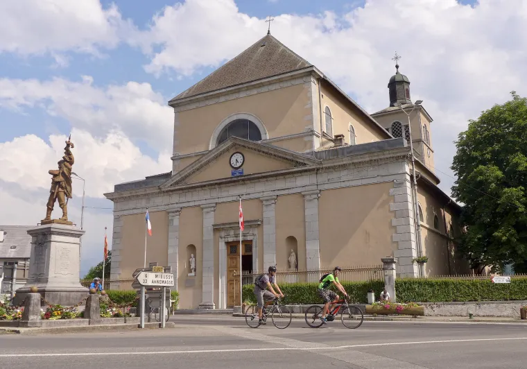 Cyclistes devant l'Église Saint-Jean-Baptiste de Taninges